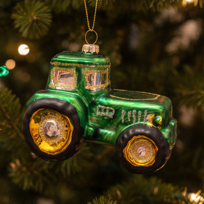 Glass tractor Christmas ornament on Christmas tree.