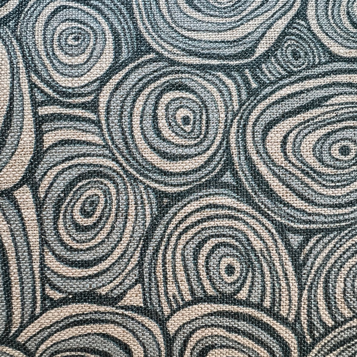 Close-up of Frenchmans Growth Rings linen fabric showing blue concentric ring pattern on natural linen