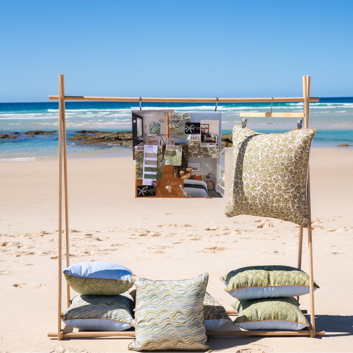 Linen cushion collection displayed on the beach in green blue and natural coastal tones
