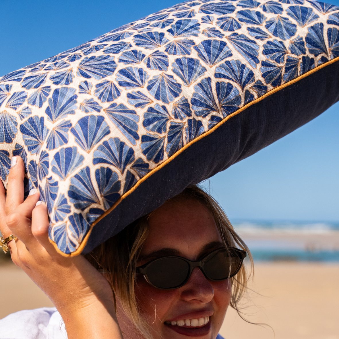 Mariner Shells linen cushion showing printed front, blue back and contrasting ochre piping