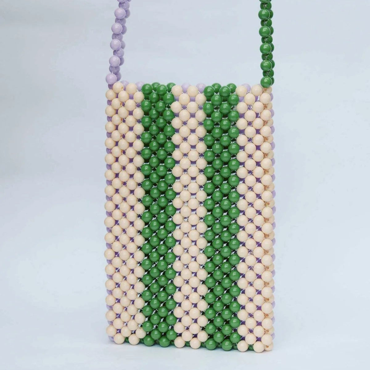 Beaded bag with green and beige pattern on a light gray background