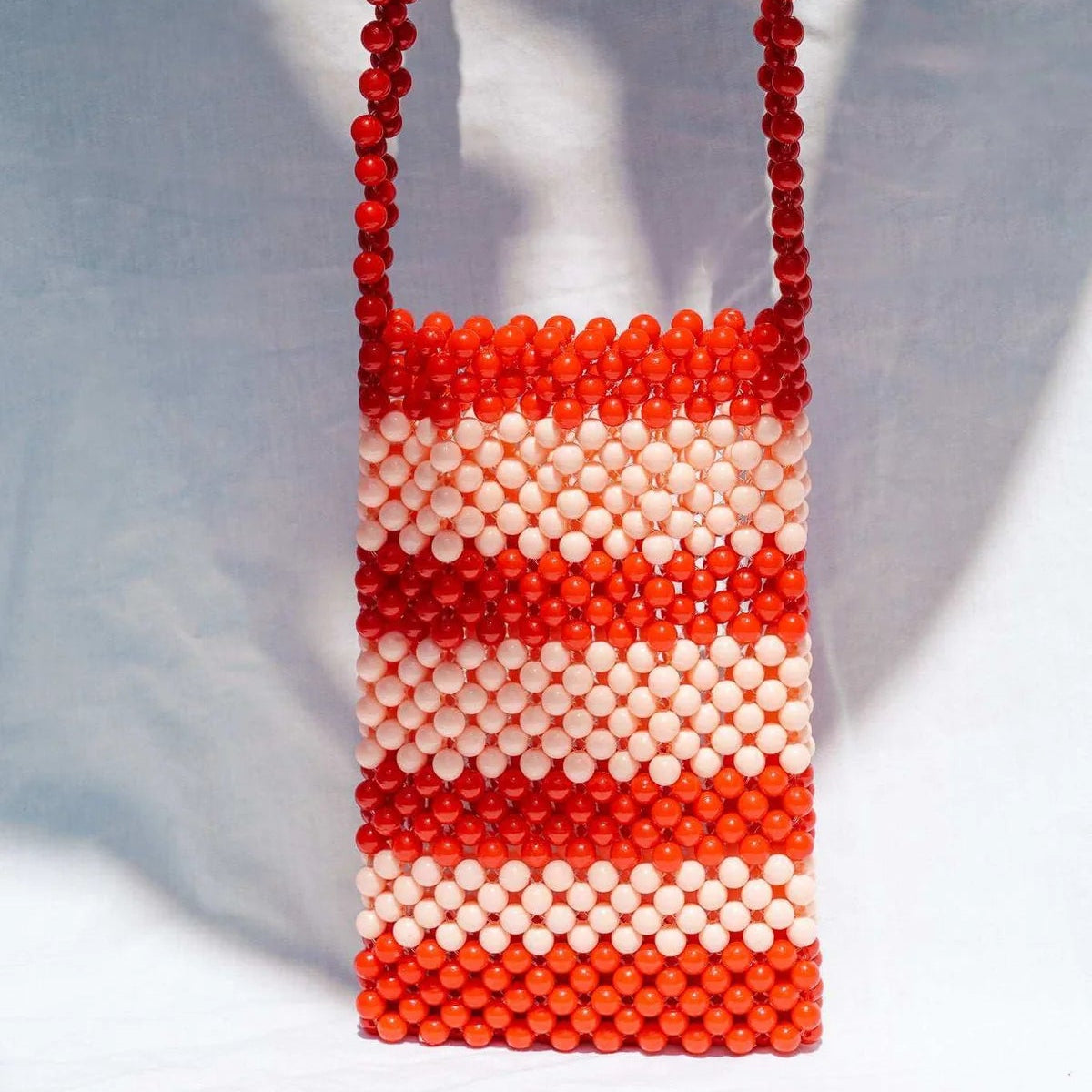 Beaded handbag with red and white pattern on a white background
