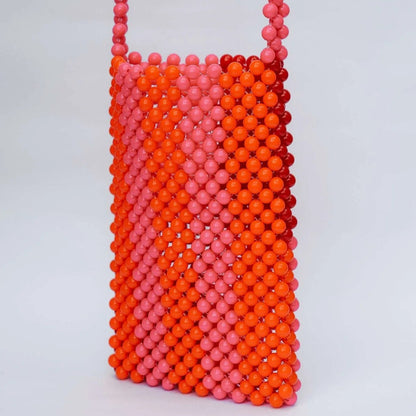 Beaded handbag with pink and orange gradient on a light gray background