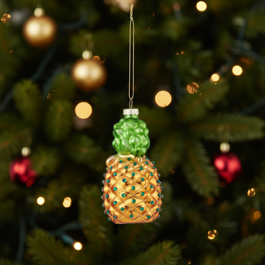 Glass pineapple Christmas ornament hanging on a Christmas tree