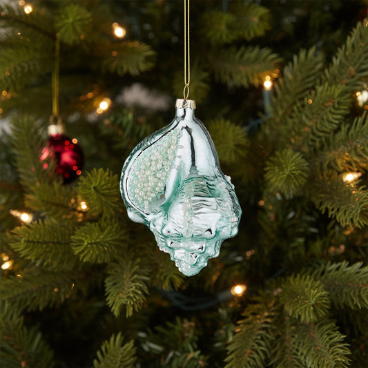 Glass seashell Christmas ornament hanging on a Christmas tree