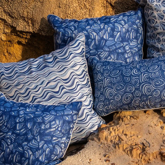 Pacific linen cushion covers in Straddie Stripe, Pipi, Growth Rings and Shells prints styled outdoors
