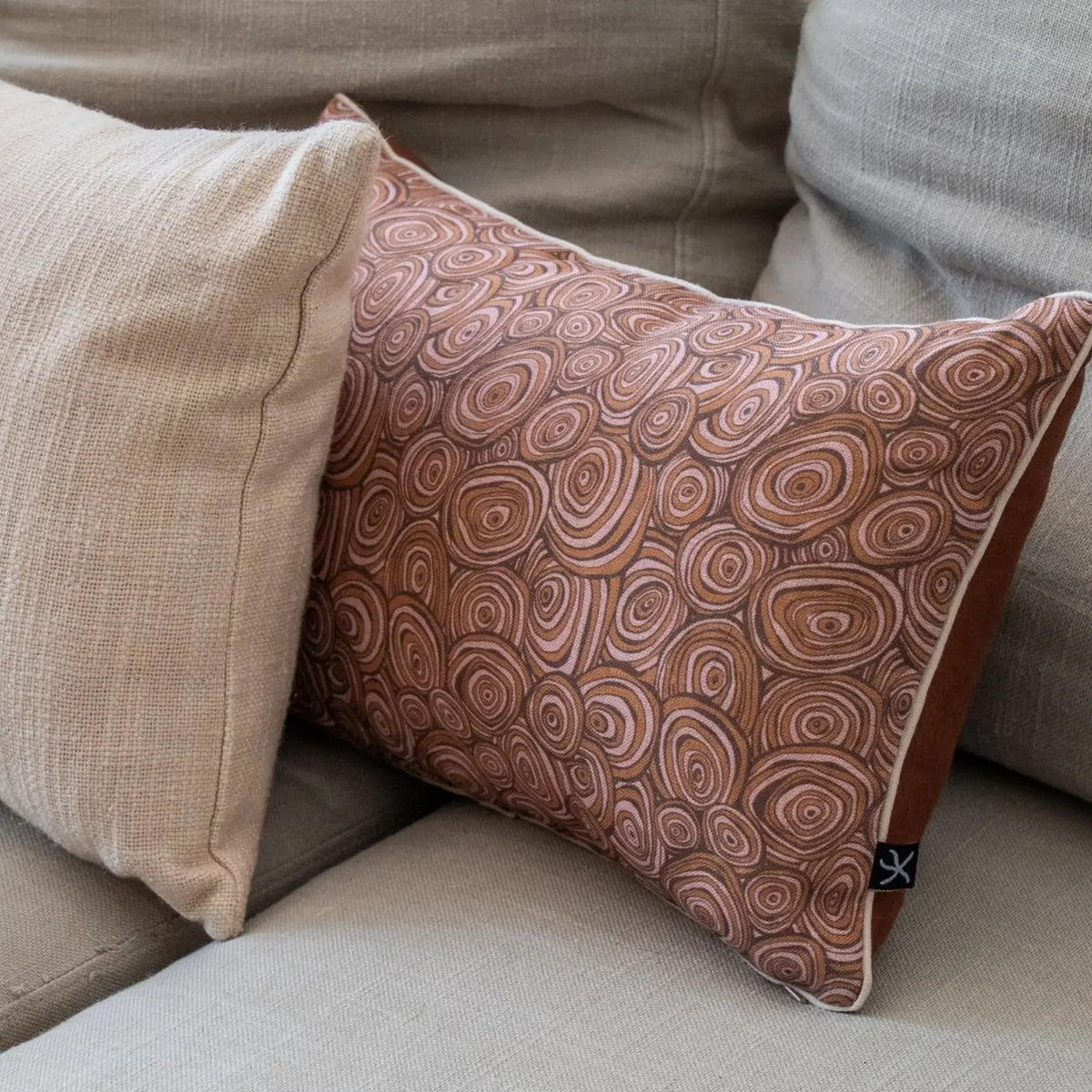 Claytons Growth Rings rectangular linen cushion cover styled with neutral cushions on a lounge