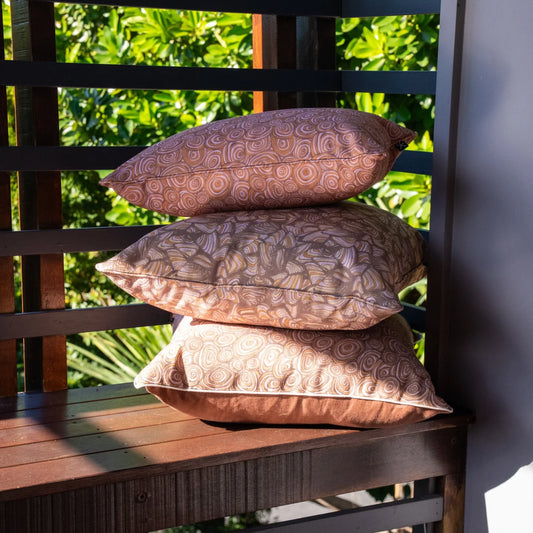 Claytons outdoor indoor cushion covers in coordinating Growth Rings and Pipi prints stacked on an outdoor bench.