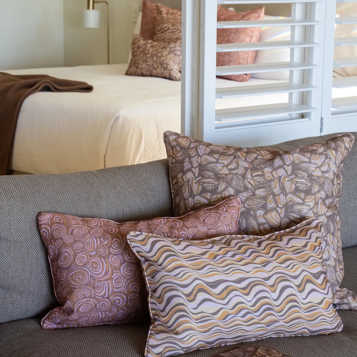 Claytons outdoor indoor cushion covers featuring Straddie Stripe, Growth Rings and Pipi prints styled together on a lounge.