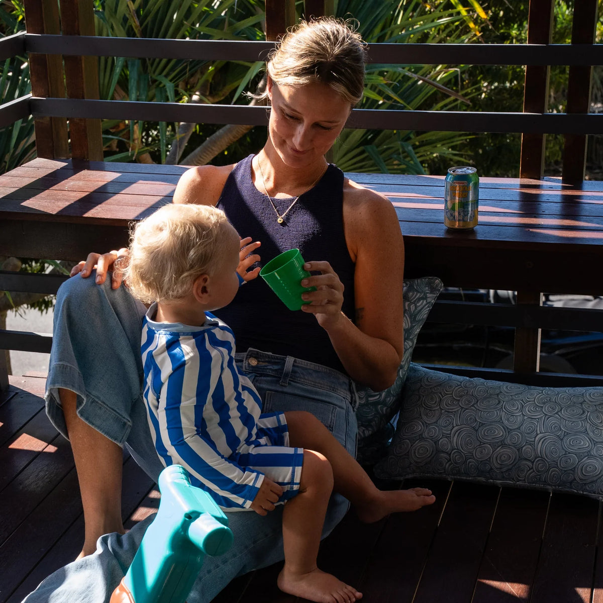 Outdoor Indoor Growth Rings cushion cover in Frenchman styled on an outdoor deck bench, with a mother and toddler