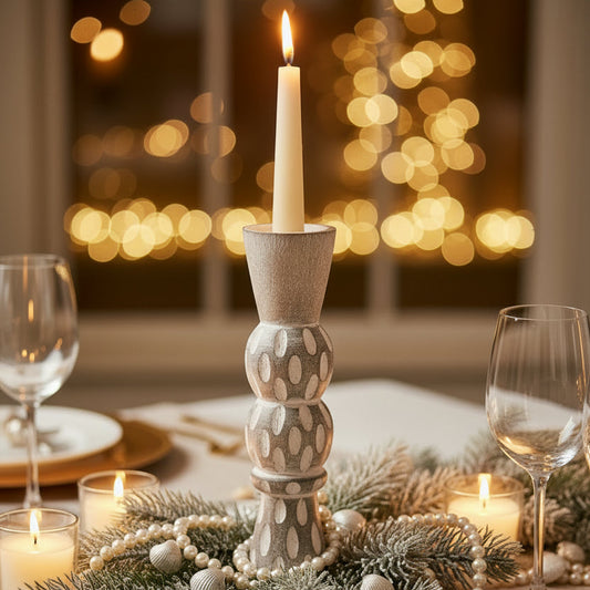  Small white washed timber candle holder with a lit candle on a festive table