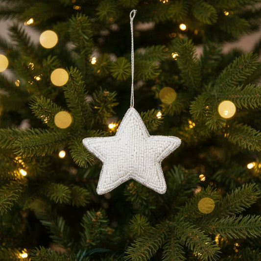 White beaded star Christmas decoration hanging on a Christmas tree